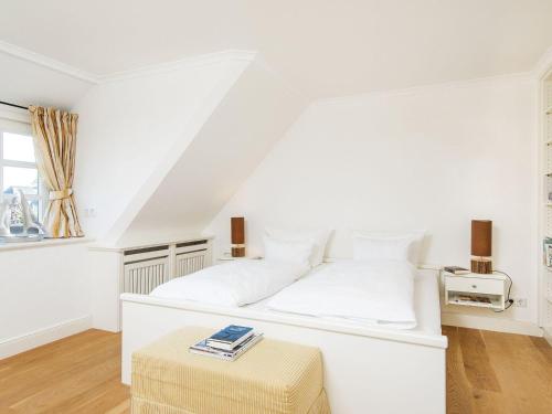 a white bedroom with a white bed and a table at Haus-Peter in Kampen