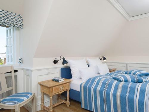 a bedroom with a blue and white bed and a table at Rasmus-5 in Kampen