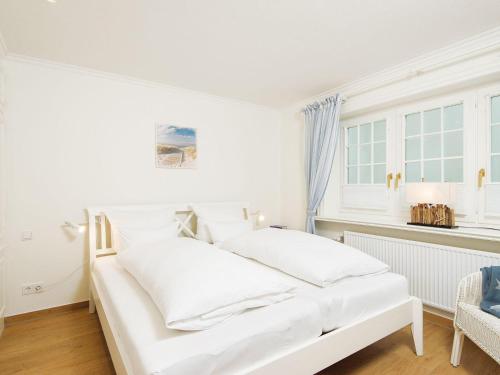 a white bed in a room with a window at Heideblick in Kampen