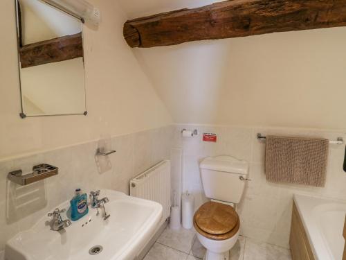 a white bathroom with a toilet and a sink at Betty's Barn in Eaton