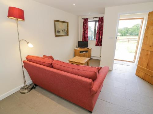 a living room with a red couch and a lamp at Kite's Nest in Eaton