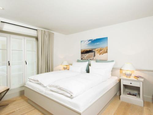 a white bedroom with a large bed with white sheets at Nug-Pot-House in Kampen