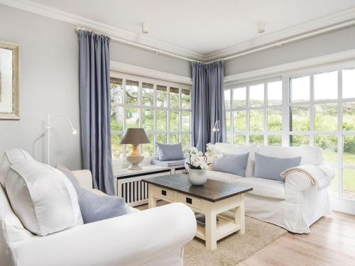 a living room with white furniture and large windows at Uhlenhof-E in Kampen