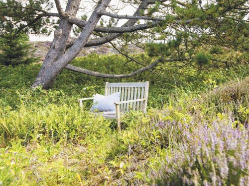 カンペンにあるUhlenhof-Eの木の下の芝生に座る白いベンチ