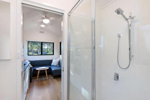 a bathroom with a shower with a glass door at Reflections Moonee Beach - Holiday Park in Moonee Beach