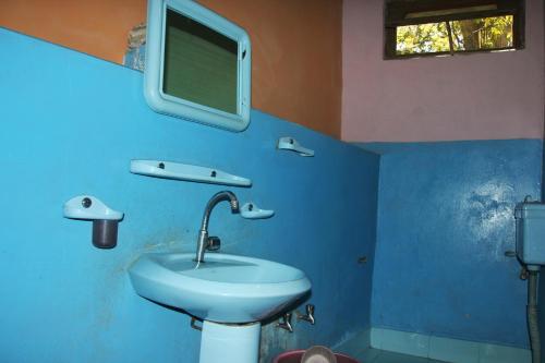 a bathroom with a sink and a tv on the wall at Rakaposhi Amin Hotel & Restaurant Pissan Hunza Nagar Gilgit Baltistan in Gilgit