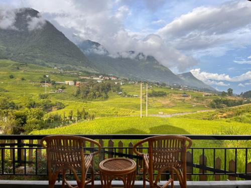two chairs and a table on a balcony with a mountain at S Plus Bungalow in Sa Pa