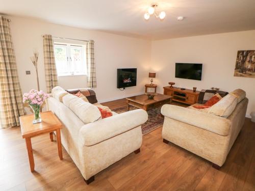 a living room with two couches and a tv at The Lodge in Stockport