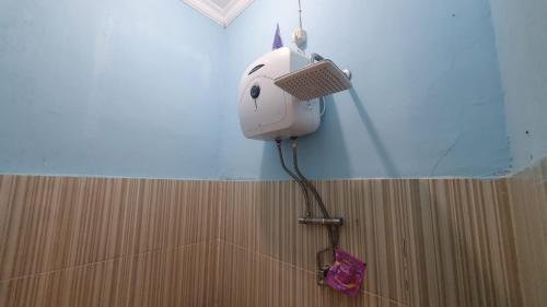 a hair dryer on the wall of a shower at RedDoorz Syariah At Demasto Homestay Jember in Jember