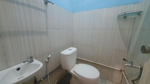 a bathroom with a toilet and a shower and a sink at RedDoorz Syariah At Demasto Homestay Jember in Jember