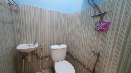 a bathroom with a toilet and a sink at RedDoorz Syariah At Demasto Homestay Jember in Jember