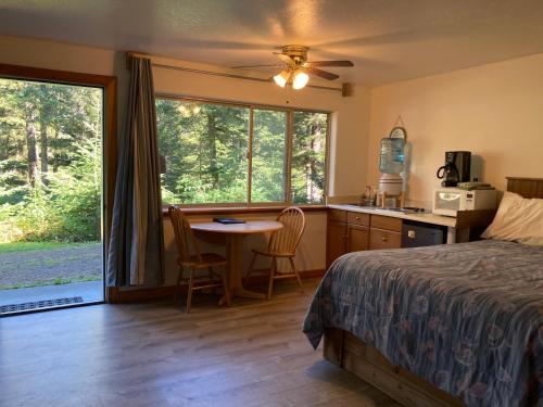 a bedroom with a bed and a table and a kitchen at Beach Roadhouse in Haines