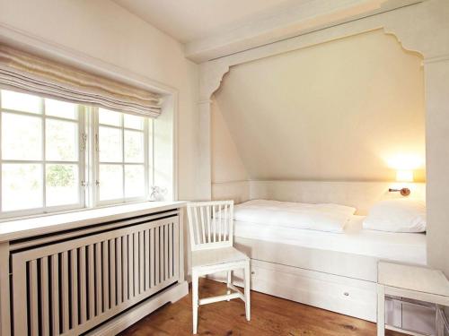 a white bedroom with a bed and a window at Grosser-Wal in Munkmarsch