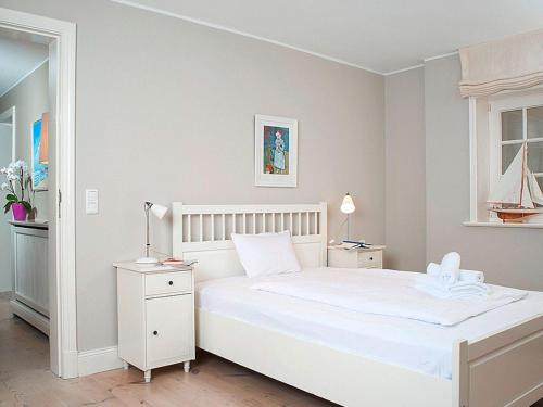 Un dormitorio blanco con una cama blanca y una ventana en Haus-zum-Leuchtturm en Kampen