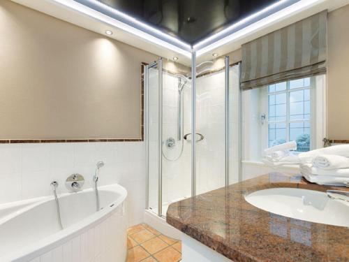 a bathroom with a tub and a shower and a sink at Prahl-Hues-4 in Kampen