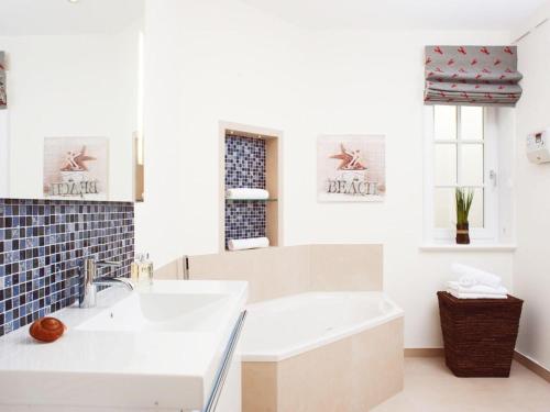ein weißes Badezimmer mit einer Badewanne und einem Waschbecken in der Unterkunft Wuldehof  in Kampen
