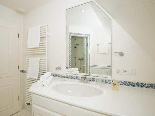 a white bathroom with a sink and a mirror at Haus-Werner in Kampen