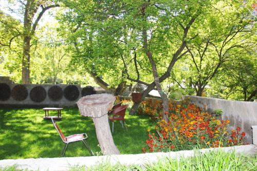 a garden with a table and chairs and flowers at Rakaposhi Amin Hotel & Restaurant Pissan Hunza Nagar Gilgit Baltistan in Gilgit
