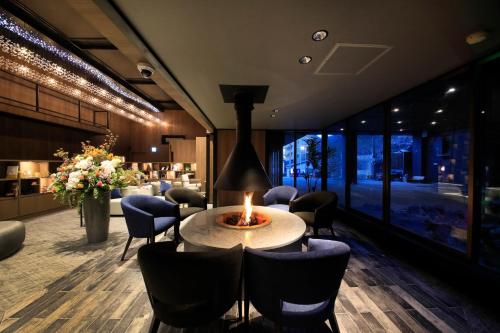 a lobby with a table and chairs and a fireplace at Naruko Fuga in Osaki