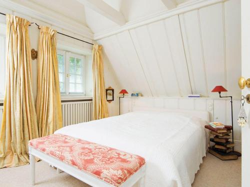 a bedroom with a white bed and yellow curtains at Pueckdeel in Kampen