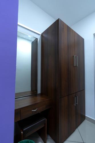 a wooden cabinet with a mirror in a bathroom at Vasudevam Premium Suites in Trivandrum