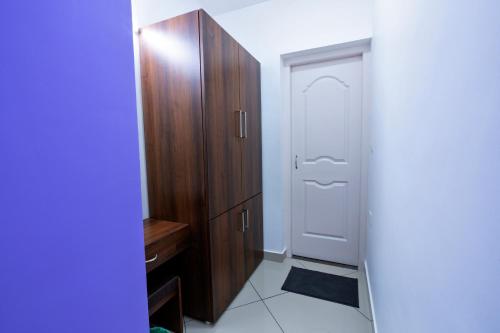 a closet with a wooden cabinet next to a door at Vasudevam Premium Suites in Trivandrum