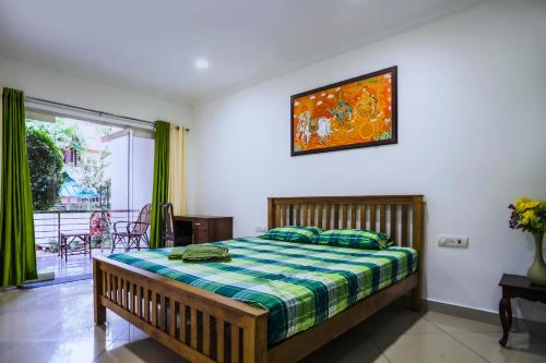 1 dormitorio con 1 cama y una foto en la pared en Vasudevam Premium Suites, en Trivandrum