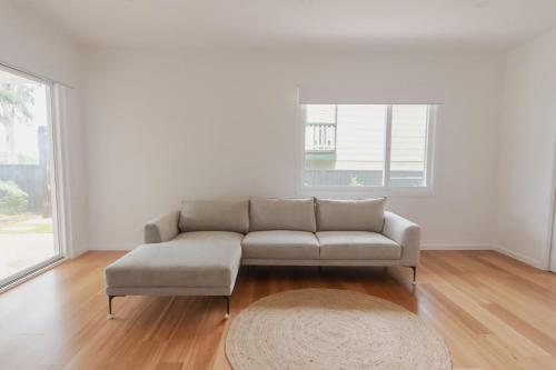 a living room with a couch and a rug at Palm Tree Retreat in Mollymook