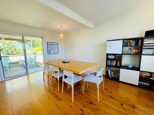 a dining room with a wooden table and chairs at Relaxed Coastal Retreat in Mollymook
