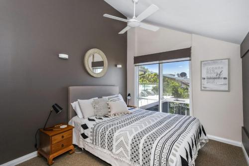 a bedroom with a bed and a ceiling fan at Surfers Reef Escape Mollymook in Mollymook