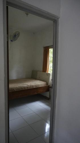 a mirror in a room with a bed and a window at Pondok zidane in Kukupu