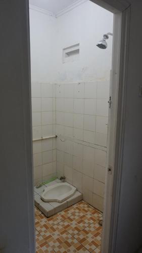 Habitación con suelo de baldosa y baño con aseo. en Pondok zidane en Kukupu