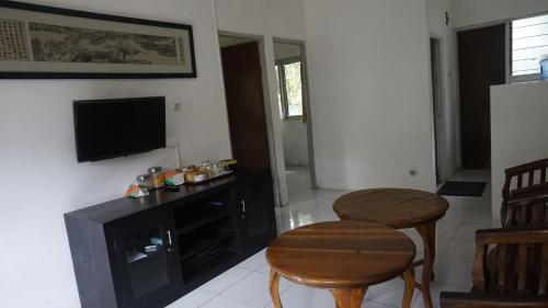 a living room with a television and two stools at Pondok zidane in Kukupu