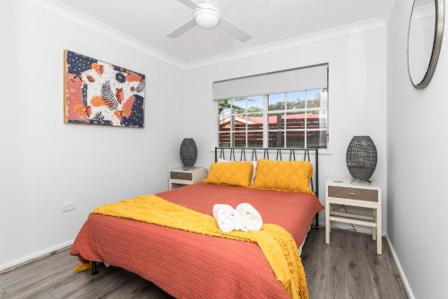 Un dormitorio con una cama con dos zapatos blancos. en Sunnyview Mollymook, en Mollymook