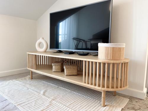 a television on a wooden stand in a living room at Apartament Grossa w stylu Japandi - Dream Apart in Bielsko-Biała