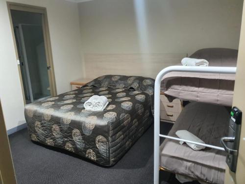een kleine kamer met een bed en een stapelbed bij Kambah Inn in Kambah