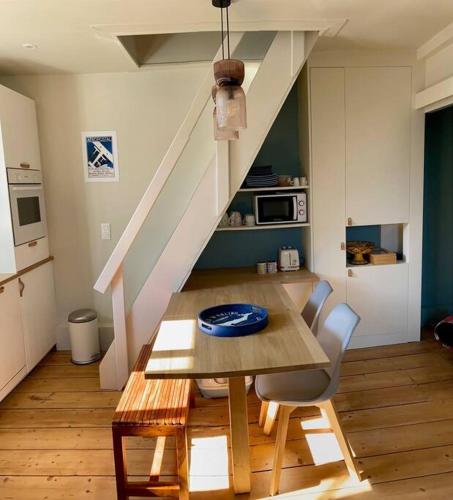 - une table à manger et des chaises dans une cuisine avec un escalier dans l'établissement Duplex plage, à Trouville-sur-Mer