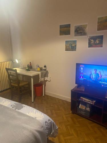 a living room with a tv and a table and a bed at Quartier Mazarin in Aix-en-Provence