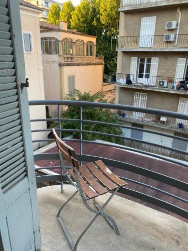 un banco sentado en el balcón de un edificio en Quartier Mazarin, en Aix-en-Provence