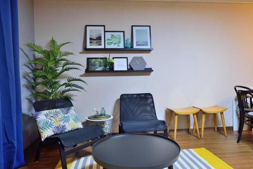 a room with chairs and a table and a plant at Jeju Claire de lune in Jeju