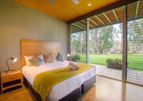 ein Schlafzimmer mit einem großen Bett und einem großen Fenster in der Unterkunft Cape Horn Vineyard 5 Bedroom Riverfront House on Working Vineyard in Echuca
