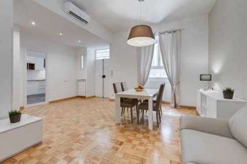 a dining room and living room with a table and chairs at Vantaggio Suites in Rome