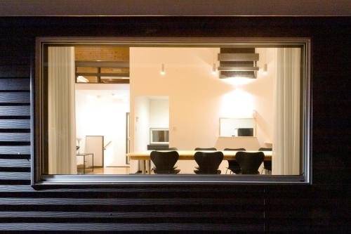 a dining room with a table and chairs through a window at Villa Noël Hakone Fuji Sauna&Open Air Bath in Hakone