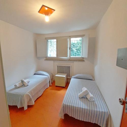 a room with two beds and a window at Hotel Maddalena in Marina di Ravenna