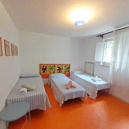 a room with two beds and a table at Hotel Maddalena in Marina di Ravenna