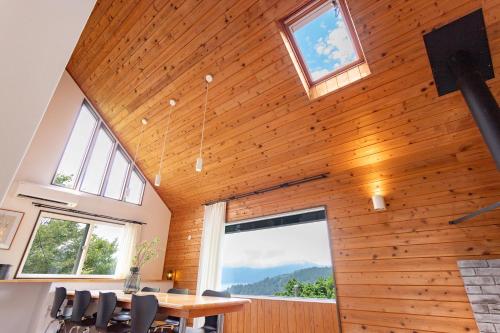 a dining room with a wooden ceiling with windows at Villa Noël Hakone Fuji Sauna&Open Air Bath in Hakone