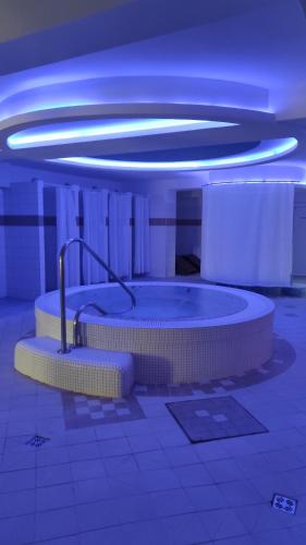 a bathroom with two tubs in a room with blue lights at Hotel SOREA TITRIS in Tatranská Lomnica