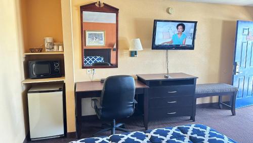 a room with a desk and a tv on a wall at Apollo Lodge and RV Park in Fairfield