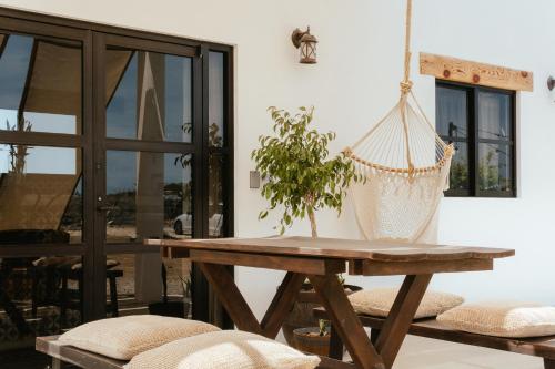 a hammock chair and a table in a room at Casa De Surfos Cerritos’s Beach in San Carlos
