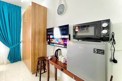 a microwave on top of a refrigerator in a room at Alanis Studio Suite {shortstay} in Sepang
